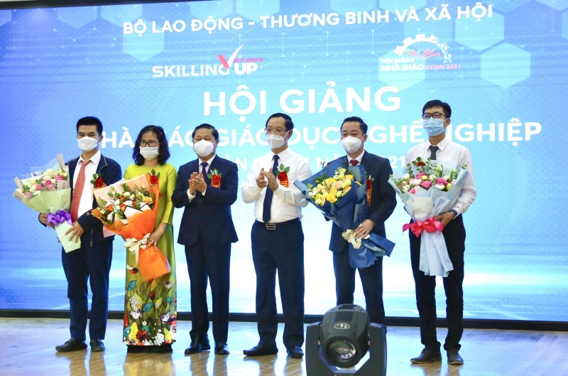 Thứ trưởng Lê Tấn Dũng, Tổng cục trưởng Trương Anh Dũng tặng hoa cho đại diện Ban tổ chức, giám khảo và nhà giáo tham gia Hội giảng